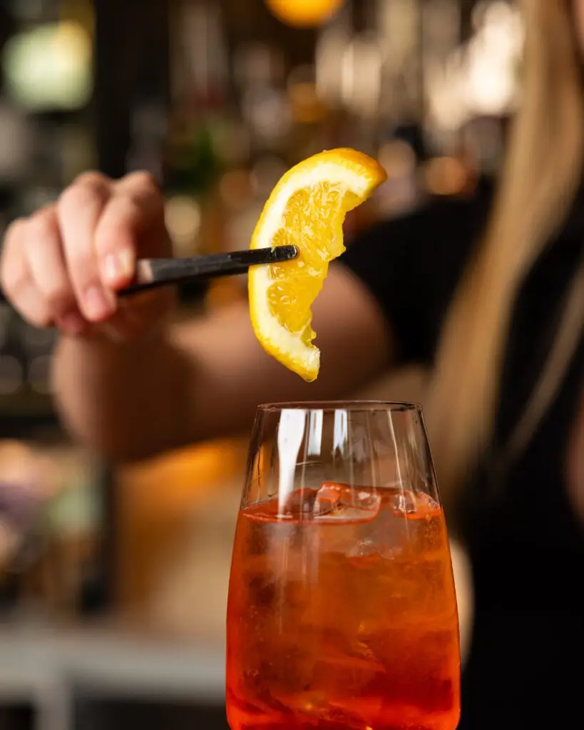Aperol Spritz mit Orangenscheibe vor der Bar im Enzo in Wien