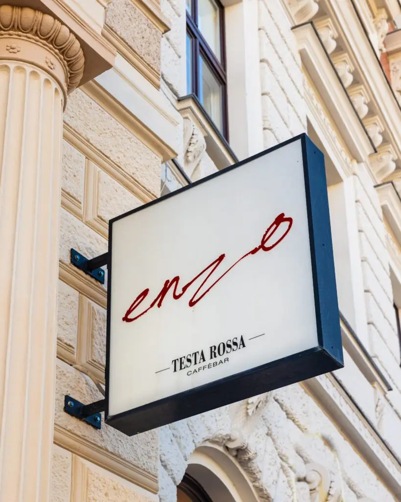 Außenansicht der Pizzeria Enzo mit einem Schild, auf dem das Enzo Logo zu sehen ist
