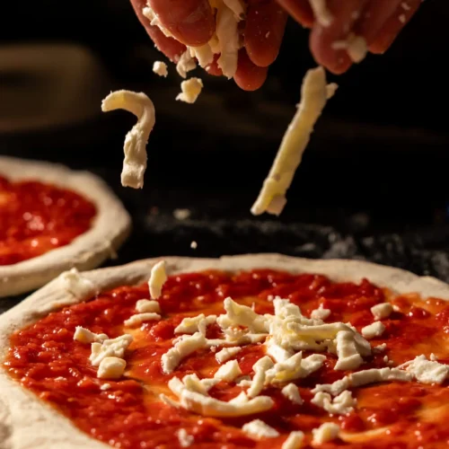 Eine Pizza wird mit frischen Mozzarella belegt